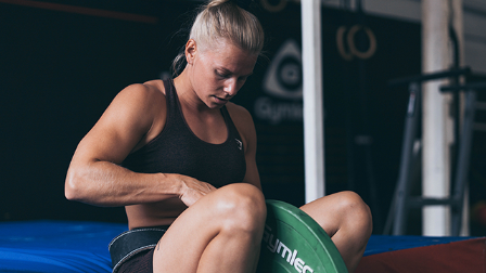Malin Malle preparing for weighted pull-ups with dip belt