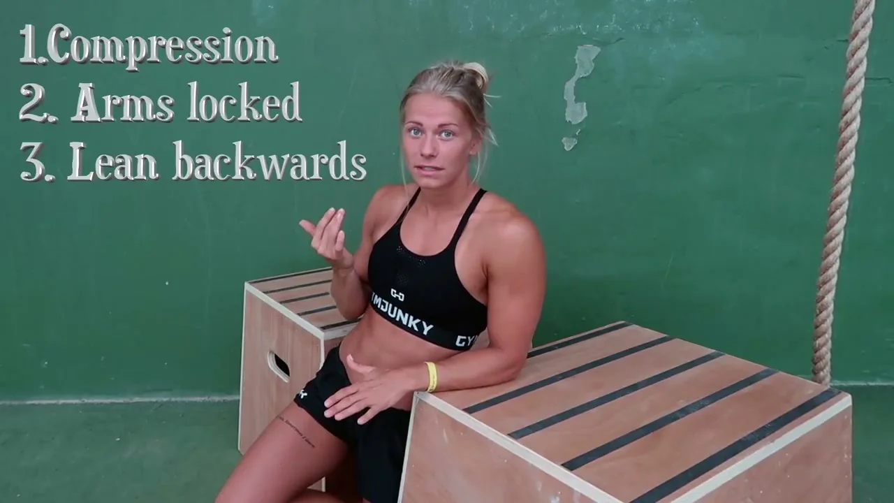 Malin demonstrating V-sit hold position on two boxes used as parallel bars
