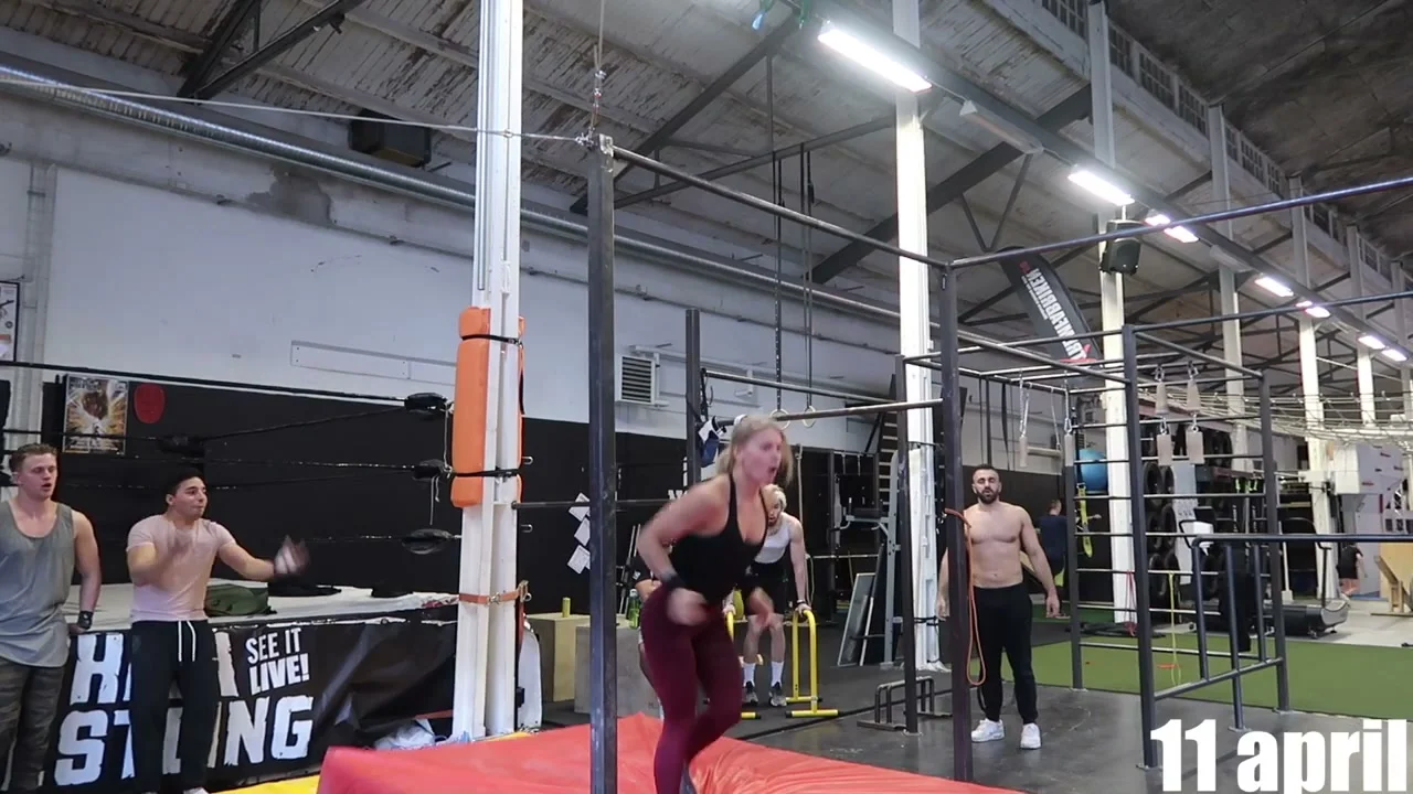 Malin Malle swinging on the bar during a swing 540 attempt at an outdoor calisthenics park