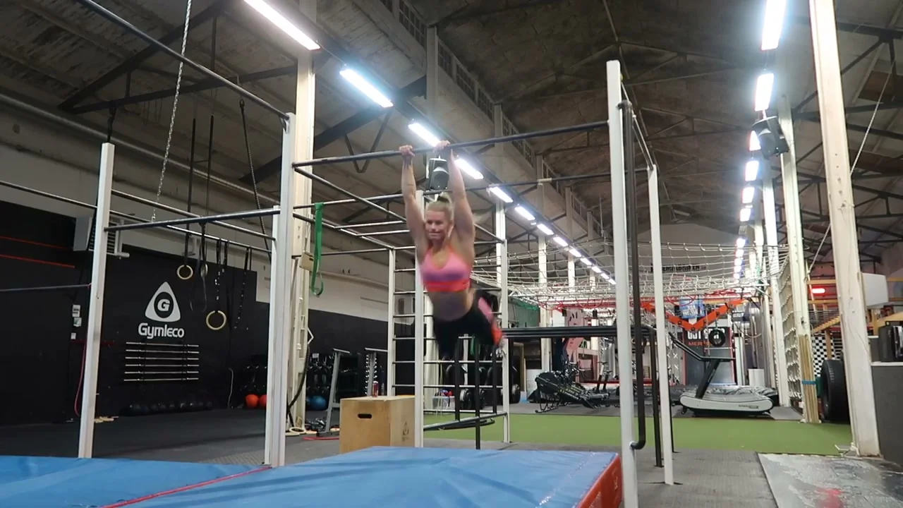 Malin training freestyle calisthenics on bars during a difficult practice session